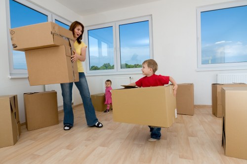 Movers carrying furniture through a flat building entrance in Westhampstead