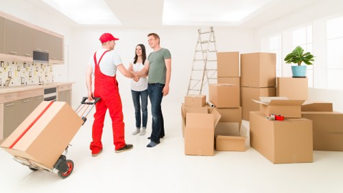A moving team assessing access and protecting property before lifting furniture