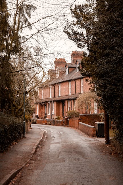 Close-up view of a brick wall with a street sign reading 'LOWER TERRACE NW3' attached to it. The sign features white uppercase lettering on a green background, with a slightly weathered appearance. Th